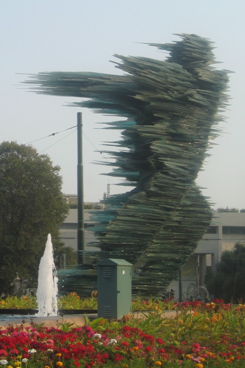 A runner in glass, sculpture in front of an Olypmic venue