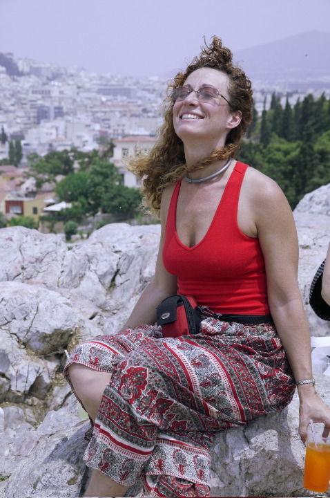 Debbie braves the slippery marble rocks to view the urban area of Athens below